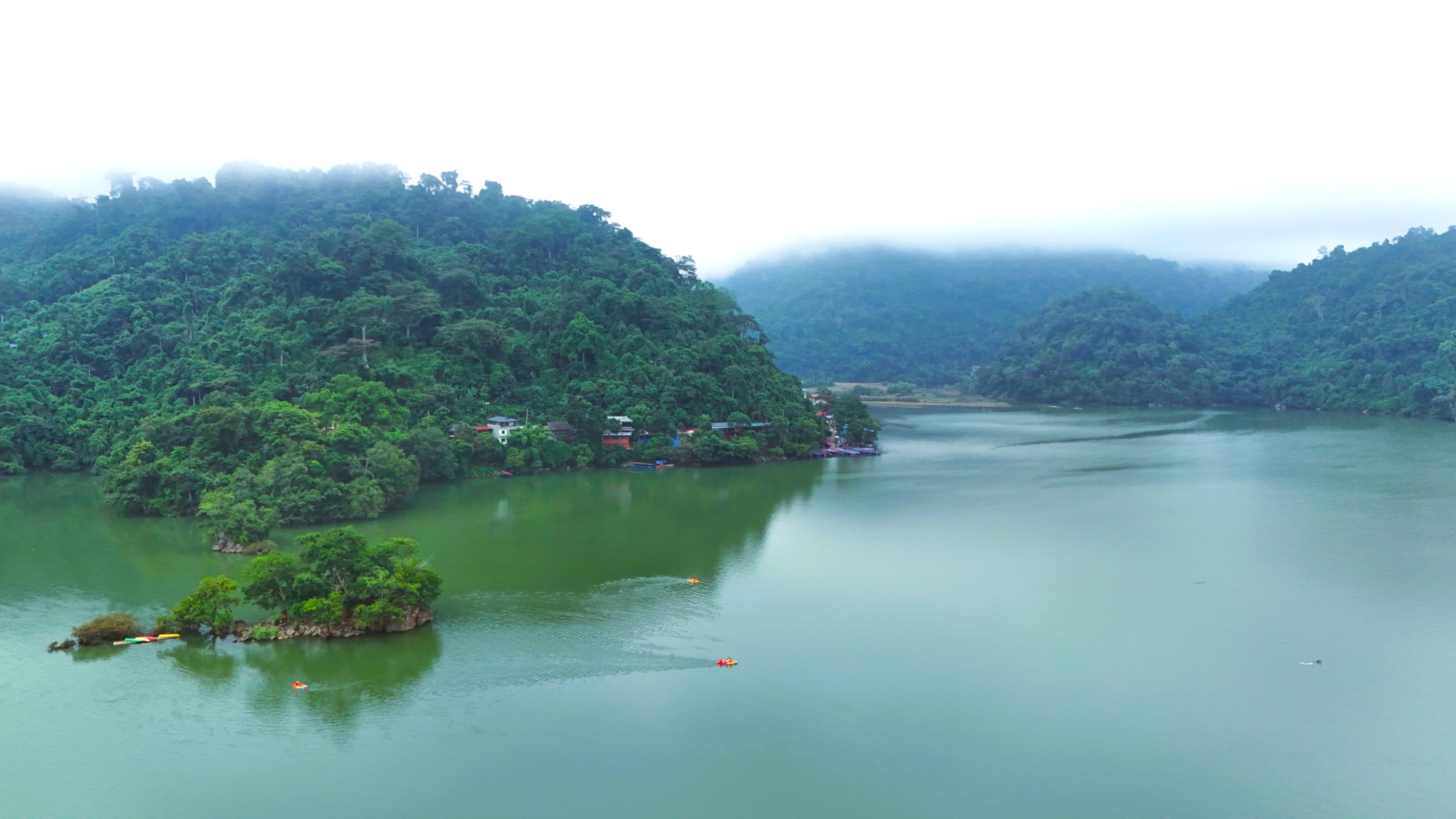 Emerald waters of Ba Be Lake surrounded by limestone mountains
