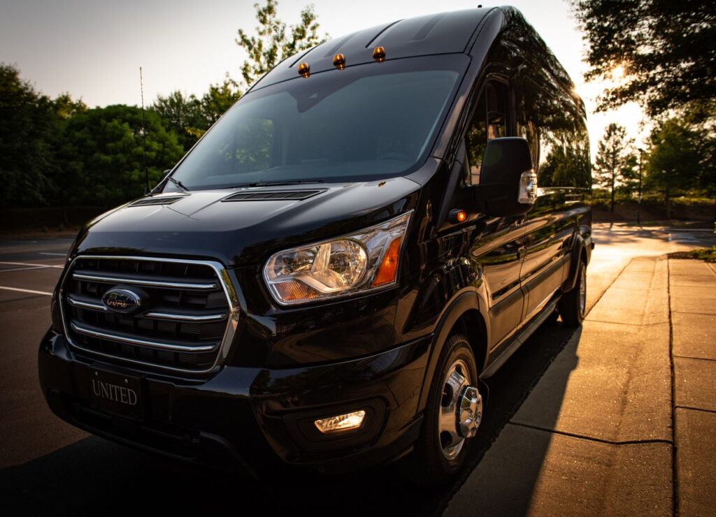A stylish black van parked on a city street at sunset, highlighting its polished exterior.
